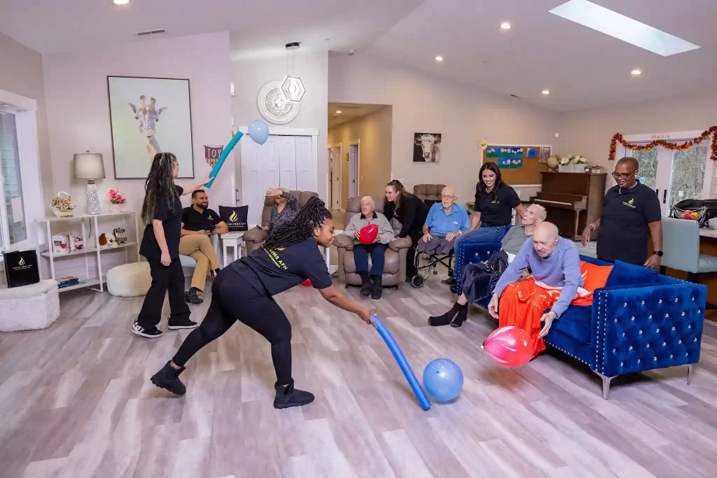 Friendly caregivers leading group activities for seniors in a cozy home-like environment in Kirkland