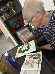 senior resident participating in creative learning at Caring Arms Adult Family Homes in Bonney Lake